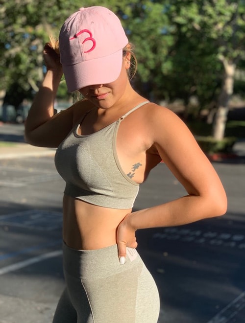 physically fit woman wearing pink cap