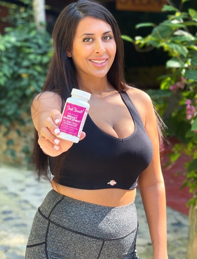 woman holding breast enhancement supplement bottle